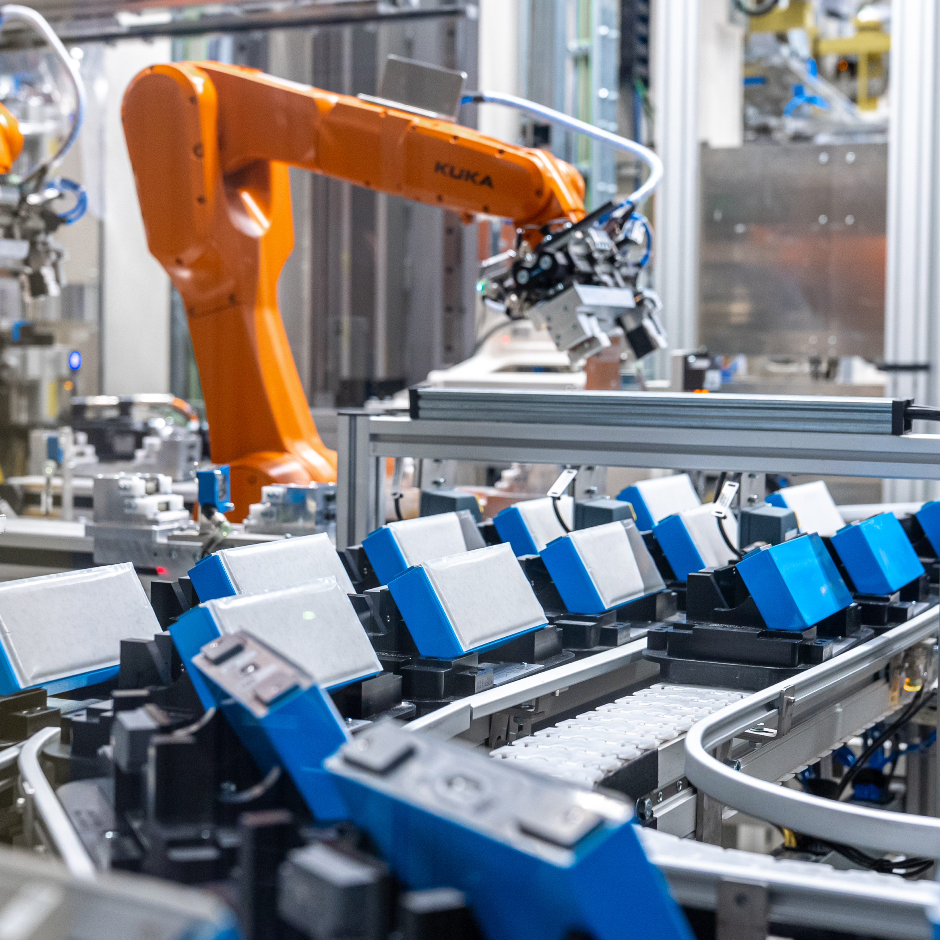 Die Nahaufnahme mehrerer blau-weißer Batterien auf Band im BMW Werk